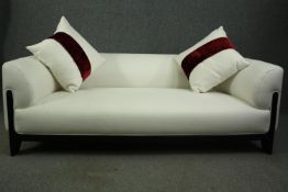 A contemporary sofa, with white upholstery and ebonised supports. H.61 W.202 D.85cm.