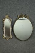 A vintage gilt metal oval wall mirror with vine leaf cresting, and a smaller white painted and