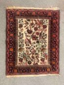 A 20th century Persian rug, with a central ivory ground and floral decoration with bird motifs. L.