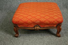 A George II style carved walnut footstool, with red damask style upholstery. H.23 W.52 D.52cm.