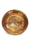 An 18th century or possibly earlier German brass alms dish with repousse design of an angel with two