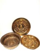 Three brass 19th century or earlier German charger/alms dishes with repousse design, featuring lions