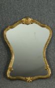 A 19th century style continental gilt shaped wall mirror with foliate cresting. H.68 cm W. 50 cm.