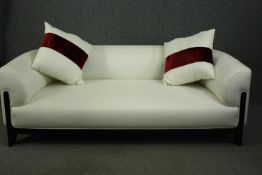 A contemporary sofa, with white upholstery and ebonised supports. H.61 W.202 D.85cm.