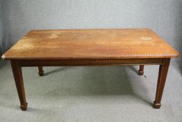 An early 20th century walnut dining table with carved frieze and chamfered legs. H.74 W.180 D.105cm.
