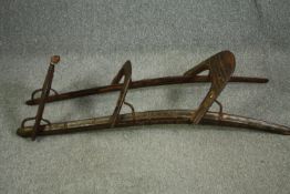 A hardwood camel saddle with engraved metal mounts. H.42 W.135 D.46cm.