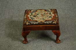 A George II style walnut footstool with tapestry upholstery. H.26 W.40 D.33cm.
