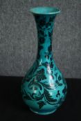 An Islamic earthenware vase with turquoise glaze and floral decoration, indistinctly signed to the