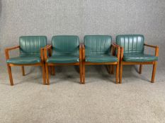 A set of four mid century teak framed armchairs in faux grained leather upholstery by LM Furniture