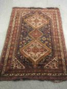 A Shiraz carpet with stylised decoration on a midnight ground. L.200 W.140cm.