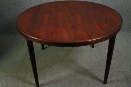A Danish mid 20th century rosewood circular top extending dining table with two additional leaves.