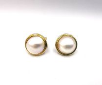 A pair of 14ct yellow gold Mabe pearl clip stud earrings, with pieced floral settings. The Mabe