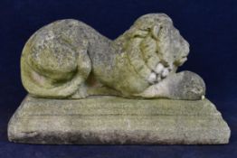 A composite stone garden figure of a lion on a plinth base. (Two parts). H.40 W.60 D.29cm