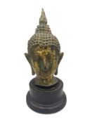 A 19th century Burmese bronze and gilded Buddha head on plinth. H.23cm.