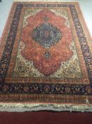 A Persian carpet with central medallion on a burgundy ground within foliate spandrels and multiple