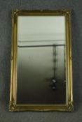 Wall mirror, contemporary foliate gilt frame with bevelled plate. H.130 W.76cm.
