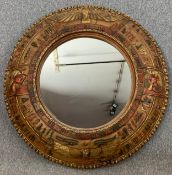A contemporary moulded wall mirror with allover Egyptian hieroglyph motifs. Dia.112cm