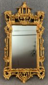 A carved giltwood wall mirror in the Chinese Chippendale style with bevelled plate. H.161 W.82cm