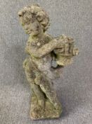 A weathered composite stone garden figure of a cherub with a basket of flowers. H.73cm