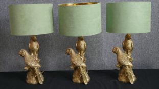 A set of three contemporary table lamps with perched parrot stems. H.58cm. (each).