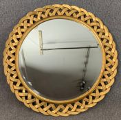 A carved giltwood wall mirror with bevelled plate. Dia.111cm