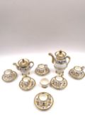 A miniature porcelain tea set with six cups and saucers, a teapot, and a coffee pot. Probably