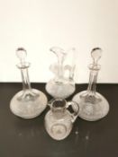 A set of four pieces of cut crystal to include two decanters with stoppers, a ewer, and a jug.