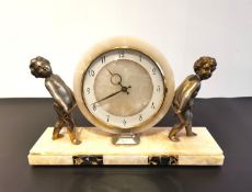 An Art Deco marble mantel clock, the face having stylised brass numerals and being held aloft by two