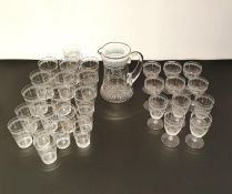 A part set of etched glasses and a jug to include ten tumblers, nine cordial, and six aperitif