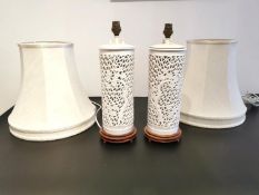 A pair of white Blanc De Chine reticulated porcelain lamps with lotus blossom decoration, with two
