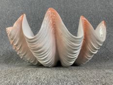 A large ceramic model of a giant clam shell. H.27 W.58 D.42cm