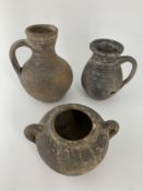 Antiquity; two Roman clay jugs and a similar twin handled vessel. H.19cm