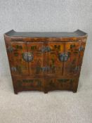 A C.1900 Chinese hand painted and lacquered side cabinet with two pairs of panel doors enclosing