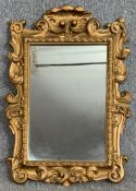 A 19th century style carved giltwood wall mirror in scrolling foliate frame. H.75 W.55cm