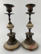 A pair of early 20th century brass and alabaster candlesticks raised on dolphin supports along