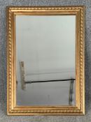 A carved giltwood wall mirror. H.106 W.77cm