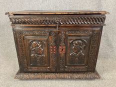 A Continental oak side cabinet with carved front and sides, possibly 18th century. H.72 W.87 D.47cm