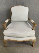 A beech framed Louis XV style armchair upholstered in ivory calico. H.93 W.76 D.77cm