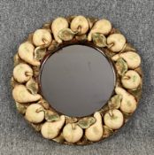 A wall mirror with plaster fruit designed frame. Dia.49cm