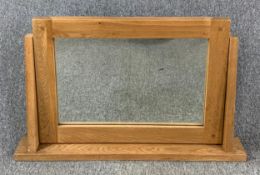 A contemporary oak framed swing mirror. H.54 W.86cm