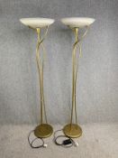 A pair of contemporary gilt metal uplighters with frosted shades. H.177cm (each)
