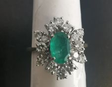 A vintage 18ct yellow and white gold emerald and diamond stylised floral cluster design. Set to