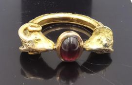 A yellow metal (tests as 14ct or higher) Roman style double rams head ring set to centre with a pink