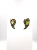 A pair of modern 9ct yellow gold and peridot stylised leaf stud earrings, each earring set with an
