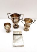 A collection of silver, including two miniature twin handled trophies and an egg cup along with a