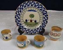 A collection of Nicholas Mosse Pottery items, three cups, a jug and a dinner plate. Plate D.28cm
