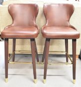 A pair of contemporary high stools upholstered in faux leather. H.102cm