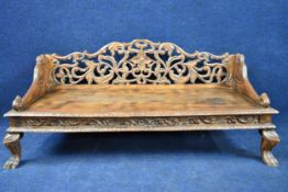 A profuseley carved Eastern teak bench. H.55 W.122 D.54cm