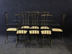 A contemporary wrought iron and plate glass dining table and the matching eight dining chairs. Table
