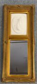 A 19th century style gilt framed pier glass with moulded relief panel. H.135 W.57cm